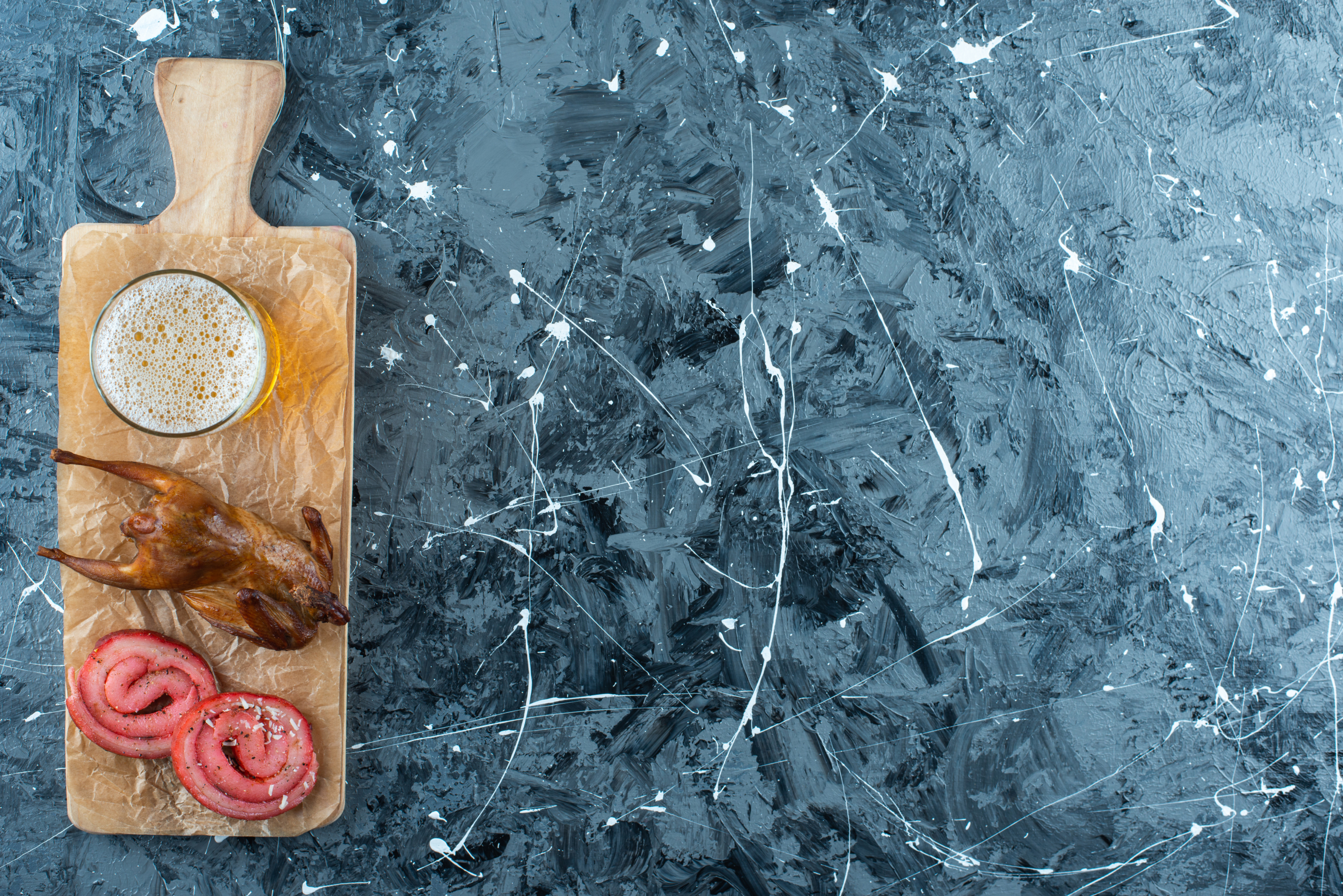 Pork lard, grill and beer on a cutting board , on the blue background. High quality photo